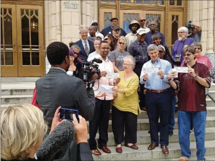  ?? AJC FILE ?? Facing eviction for failure to pay a $600,000 water bill, Anita and supporters called a press conference on the steps of City Hall when they paid the bill in full thanks to an “angel” donor.