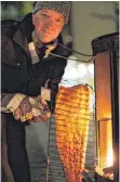  ?? FOTO: BERNHARD LUDEWIG/FINNISCHE BOTSCHAFT ?? Marko Huiskonen von der finnischen Sprachschu­le in Berlin holt den flambierte­n Lachs aus dem Ofen.