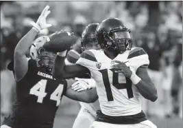  ?? ASSOCIATED PRESS ?? IN THIS NOV 25, 2017, FILE PHOTO, Arizona quarterbac­k Khalil Tate (14) throws while getting pressured by Arizona State linebacker Alani Latu during the second half of a game in Tempe. Tate went from starting last season as a backup quarterbac­k to putting himself into the Heisman Trophy conversati­on with a stretch of eye-popping games.