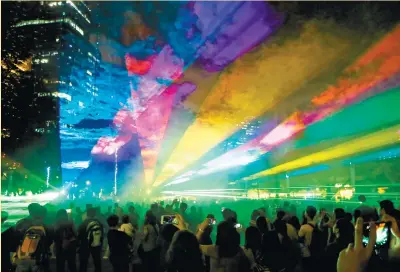  ?? (AP FOTO) ?? LIT UP. People watch the “Christmas and Light” show, which featured “dancing” lights and laser beams, in Makati City.