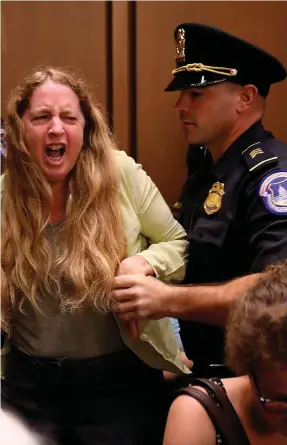  ??  ?? Anger: One of the protesters is removed after they disrupted the confirmati­on hearing for Supreme Court nominee Judge Brett Kavanaugh in Washington