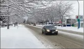  ?? Okanagan Newspaper Group ?? A car travels along a snowy Kelowna road Tuesday morning.