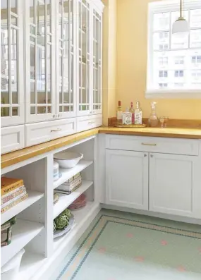  ??  ?? |ABOVE RIGHT| By going with butcher block countertop­s,
Sara was able to connect the kitchen with the original wood flooring throughout the rest of the unit. The white cabinets contrast with the warm counters and offer lots of storage space. “She originally had wanted to do maple, but I thought the white would be better to showcase her decorative items,” Susan says.