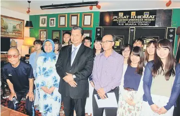  ??  ?? Idris (front third left), flanked by Jeniri (third right) and Faridah during the visit by the Japanese students at his service centre. — Photos by Jeffery Mostapa