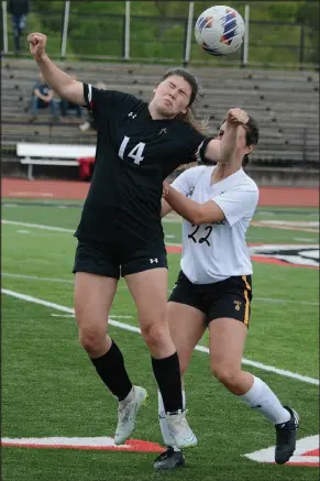  ?? Bennett Horne/McDonald County Press ?? McDonald County junior Anna Clarkson (14) gets pushed from behind by a Cassville defender while trying to receive a throw-in pass during the opening half of their game played Tuesday night at Mustang Stadium.