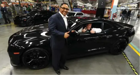  ?? RICK EGLINTON/TORONTO STAR ?? Kevin Williams, president of General Motors Canada, stands next to the first production versions of the ZL1, while Rick Hendrick gives the thumbs-up. Below, Hendrick and Williams — along with a crowd of GM workers and media — check out a new Camaro’s...