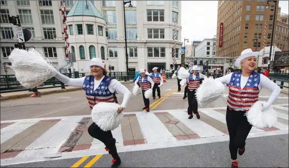  ?? (AP/Kenny Yoo) ?? Colleen Minisce (left), Janet Polley (right) and other members of the Milwaukee Dancing Grannies perform Nov. 5 during a Veterans’ Day parade in Milwaukee.