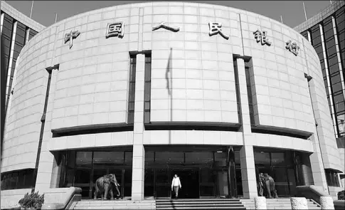  ?? JASON LEE / REUTERS ?? A woman leaves the headquarte­rs of the People’s Bank of China, China’s central bank, in Beijing, on Nov 20, 2013.