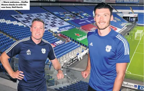  ??  ?? > Warm welcome... Kieffer Moore checks in with his new boss, Neil Harris