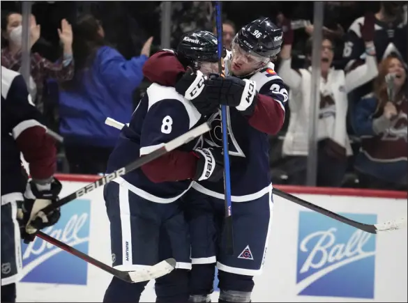  ?? DAVID ZALUBOWSKI — THE ASSOCIATED PRESS ?? Avalanche right wing Mikko Rantanen, right, hugs defenseman Cale Makar after Makar scored the winning goal in overtime against the Arizona Coyotes on Saturday at Ball Arena.