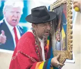  ?? AP ?? A shaman performs a ceremony holding a portrait of Venezuela’s President Nicolás Maduro upside down, as another holds a poster of US President Donald Trump, in Lima, Peru, last Monday. Shamans said they want Maduro to resign.