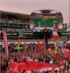  ??  ?? Il mare di folla e le bandiere Ferrari sotto il podio di Monza