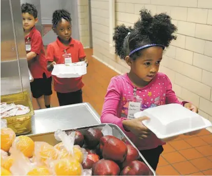  ?? LLOYD FOX/BALTIMORE SUN ?? Natalia Carter stands in the lunch line at Beechfield Elementary/Middle School as the prekinderg­arten class gets lunch. Starting this week, all students in the city school system will receive free breakfast and lunch.