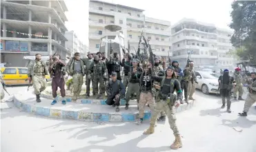  ?? (Khalil Ashawi/Reuters) ?? TURKISH-BACKED Free Syrian Army fighters celebrate yesterday after taking control of Afrin in northwest Syria.