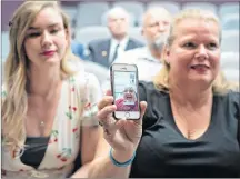  ?? CP PHOTO ?? Retired sergeant Lewis Pearce is on the phone held by his daughter Lisa after the family donated military manuals at the Military Museum in Calgary on Friday.