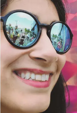  ?? STAFF PHOTOS BY ARTHUR POLLOCK ?? ‘OUTSIDE THE BOX’: Boston’s new park, Undergroun­d at Ink Block, top right, is reflected in the sunglasses of Julia McAlpin, above. Artist and co-curator Marka27 finishes up his work on a mural, right. Other murals, below, line the park between the...