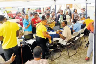  ?? PHOTOS BY CARL GILCHRIST ?? While outside, persons try to register for the Programme of Advancemen­t Through Health and Education (PATH) during a Ministry of Labour and Social Security town hall consultati­on held on Wednesday in Brown’s Town, St Ann.