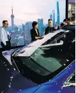  ?? AFP/GETTY IMAGES ?? Visitors look at Tesla’s Model S car during a Shanghai trade expo earlier this month. Prices were lowered for the Model S and Model X vehicles by 12 per cent to 26 per cent.