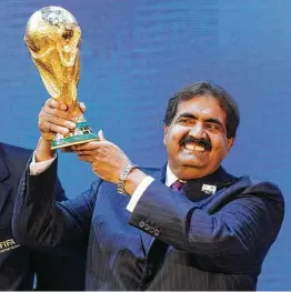  ?? Anja Niedringha­us / AP ?? El jeque Hamad bin Khalifa Al-Thani sostiene la Copa del Mundo de la FIFA tras el anuncio de que Qatar será sede del torneo en 2022, el 2 de diciembre de 2010.