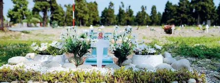  ?? (Piaggesi/Ansa) ?? Il ricordo Una delle tombe sulle quali i familiari hanno posto foto e fiori dei presunti deceduti senza parenti
I fatti
● Nel pieno dell’emergenza Covid sono stati sepolti per errore alcuni defunti nel campo 87, quello delle salme non richieste
● La legge prevede tempi lunghi per la riesumazio­ne di morti per contagio
● I parenti chiedono una deroga per poter dare ai loro cari tombe dignitose