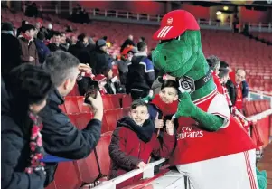  ?? PHOTO: REUTERS ?? Extinct . . . Arsenal mascot Gunnersaur­us poses for a photograph with fans inside Emirates Stadium in London before a Europa League match in February.