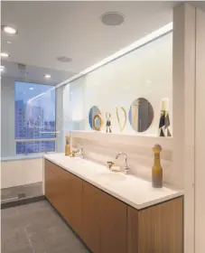  ??  ?? Above: The two-story penthouse sits on the 24th floor of the Ritz-Carlton. The penthouse offers custom furniture and tall windows framing city views. Right: Frosted glass above the dual vanity lends privacy to the master bathroom. The unit is listed...