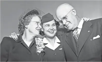  ?? COMMERCIAL APPEAL ?? “Pug” Wells, center, an American Airlines stewardess temporaril­y doubling as publicity agent for her movie brain child, “Three Guys Named Mike”, managed to sneak her parents, Mr. and Mrs. Charles G. Wells of Clarksdale, Miss, off in a corner before a luncheon at the Variety Club on 14 Feb 1951 for a little family talk. RUDOLPH VETTER / THE