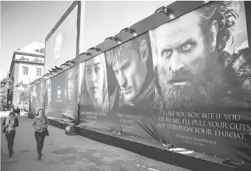  ??  ?? People walk past an advertisin­g poster to promote the HBO’s ‘Game of Thrones’ outside the Internatio­nal Game of Thrones exhibition in Stockholm on Mar 11, 2015. — AFP file photo