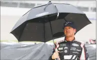  ?? Carlos Osorio / Associated Press ?? Clint Bowyer stands on pit row in the rain Sunday at Michigan Internatio­nal Speedway in Brooklyn, Mich.