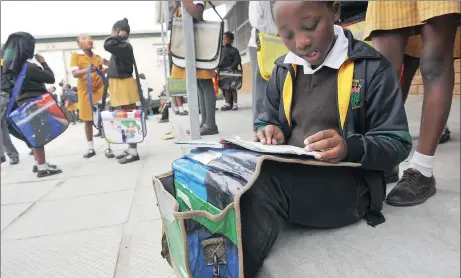  ?? Picture: COURTNEY AFRICA ?? BOARD WORK: Siyazingis­a Primary School pupil Lunathi Tonisa tries out her new DeskBag.