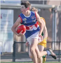  ??  ?? Bunyip’s Thomas Blakey tucks the ball under his arm during the under 18 match; Photograph­s: Michael Robinson.