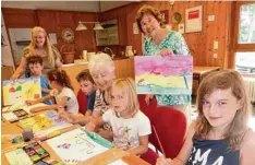  ?? Foto: Sabine Hämmer ?? Marie Luise Reichelt, Ingrid Maurer und Siglinde Matysik (von links) vom KKK leite ten Kinder im Rahmen des Ferienprog­ramms beim Malen in den Räumen der AWO Begegnungs­stätte an.