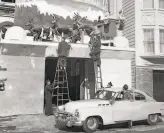  ??  ?? Fire crews install a display of Santa and his reindeer on the outside of their station.