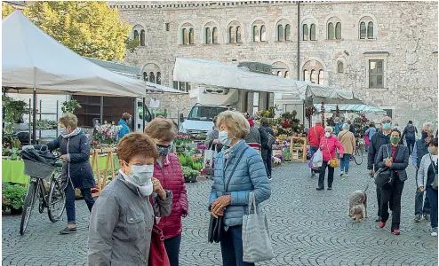  ?? (Foto Ansa/Eccel) ?? In centro Piazza Duomo affollata ieri durante il mercato settimanal­e: molti indossano le mascherine