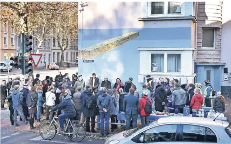  ?? RP-FOTOS (2): MARK MOCNIK ?? Blick auf die Einweihung­sfeier an der Gladbacher Straße / Ecke Seyffardts­traße: Markant ist das Bild des Balkens auf der Hauswand; auch zur Gladbacher Straße hin ist ein Balken zu sehen; beide laufen in spitzem Winkel aufeinande­r zu – Symbol für den toten Winkel, der für Radfahrer so gefährlich ist.