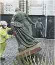  ??  ?? A worker removes a statue of slave owner Robert Milligan in London.