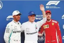  ?? Reuters ?? Mercedes’ Bottas (centre) celebrates after taking the pole with teammate Hamilton and Ferrari’s Vettel.