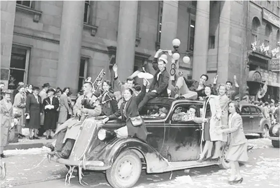  ?? Library and Archi ves Canada ?? Military personnel and civilians celebrate VE-DAY on Sparks Street in Ottawa on May 8, 1945.