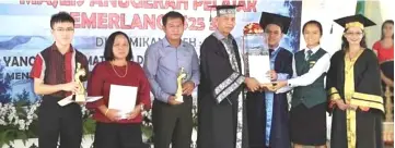  ??  ?? Stanley and Ivy (third and second right, respective­ly) receive their ‘Best Student’ awards from Penguang (centre).