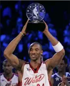  ??  ?? Lakers guard Kobe Bryant holds up the MVP trophy after his 31-point effort led the West squad to a 153-132 victory over the East.