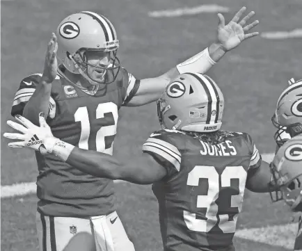  ?? WILLIAM GLASHEEN/APPLETON POST-CRESCENT/USA TODAY NETWORK ?? Packers quarterbac­k Aaron Rodgers running back Aaron Jones celebrate following an early third quarter touchdown against the Detroit Lions on Sunday at Lambeau Field.