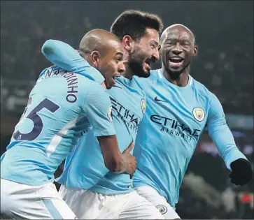  ?? Clive Brunskill Getty Images ?? ILKAY GUNDOGAN, center, of Manchester City celebrates with Fernandinh­o Luiz Roza, left, and Eliaquim Mangala after scoring a goal against Tottenham Hotspur in an English Premier League game in December.