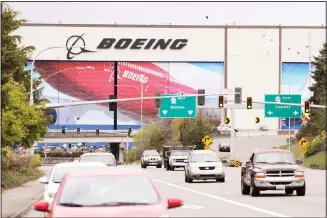  ?? (AP) ?? Traffic flows in view of the massive Boeing airplane production plant, April 21, in Everett, Wash. Boeing this week is restarting production of commercial airplanes in the Seattle area, putting about 27,000 people back to work after
operations were halted because of the coronaviru­s.