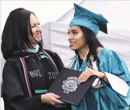  ??  ?? Capital High School Principal Channell Wilson-Segura awards a diploma to Guadalupe Avalos, 18. About 290 students graduated during the Capital High School ceremony at the school’s football field last month.
