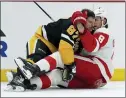  ?? MATT FREED — THE ASSOCIATED PRESS ?? Penguins star Sidney Crosby, left, and the Red Wings' Ben Chiarot mix it up during a crucial game in the Eastern Conference playoff race on Thursday night.