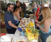  ?? DAN REIDEL — ENTERPRISE-RECORD FILE ?? Mom’s Diner general manager Aaron Smith, left, and Sara Vickery give a sample to Brie Ray, right, of Chico at the California Nut Festival, 2017.