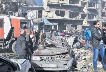  ?? EPA ?? Syrians gather at the scene of one of two car bomb attacks in government-controlled areas of Homs on Saturday.