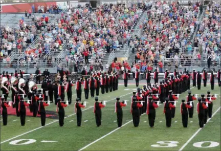  ?? JONATHAN TRESSLER — THE NEWS-HERALD ?? Mentor High School’s Fighting Cardinals Marching Band takes center stage Sept. 20 at Jerome T. Osborne Stadium as it plays the National Anthem during the start of the 2017 Lake County Music Educators Associatio­n Marching Band Festival.