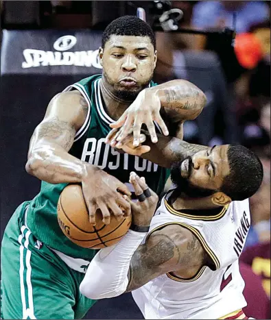  ?? AP/TONY DEJAK ?? Boston’s Marcus Smart and Cleveland’s Kyrie Irving (right) battle for a first-half rebound in the Celtics’ 111-108 victory in Game 3 of their NBA Eastern Conference series Sunday in Cleveland. The loss by the Cavaliers was their first in this season’s...