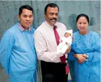  ??  ?? Dr Govinda Shenoy with the newborn and his parents at the hospital. The delivery took place at 25 weeks of gestation.